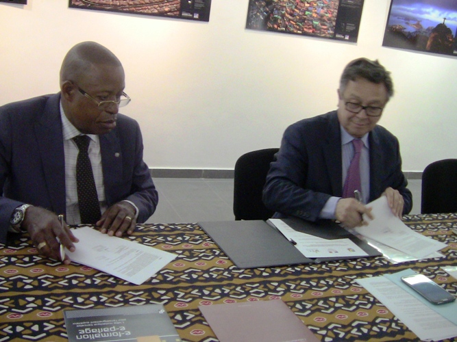 Le Pr. Jean Berchmans Labana et Philippe Larrieu signant l’accord tripartite