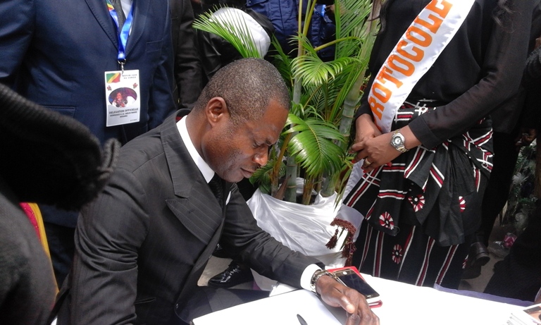 Hugues Ondaye, commissaire général du Festival panafricain de musique (Fespam) signant le registre funéraire
