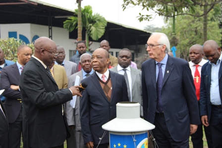 le chef de projet BEAU, le professeur Mbuyamba et Vincent Dowd devant un pluviomètre
