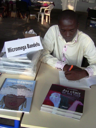Micromega Bandefu dédicaçant le recueil de poèmes Au clair de ma voix