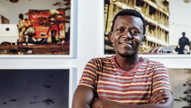 Kiripi Katembo devant ses photos à l’exposition de la Fondation Cartier