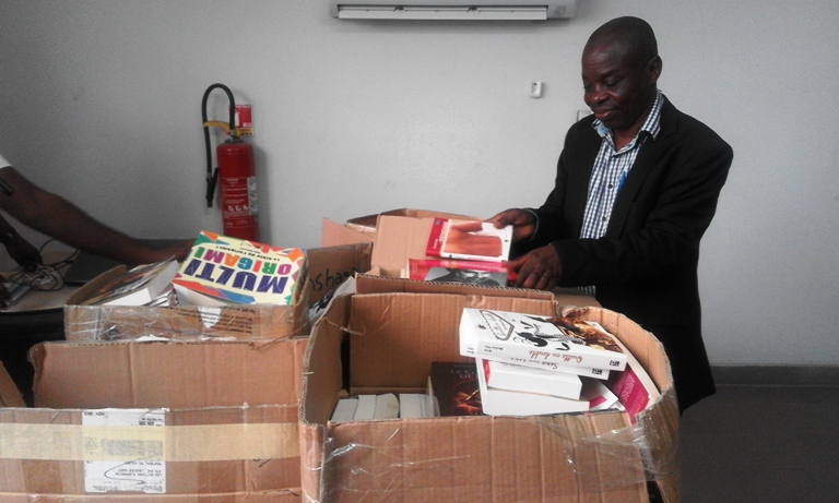 Le responsable de la médiathèque, Fulgence Kabeya, regardant de plus près ces nouveaux trésors 