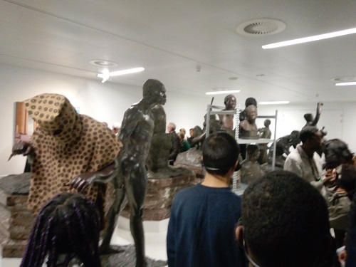 François Makanga et les élèves face aux sculptures représentant les noirs 
