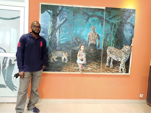 Benj Kinenga posant à côté de L’homme-léopard (Adiac)