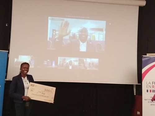 La chargée de projets de l’AUF, Nelly Mbiya, présentant le prix du candidat Lushois, Trésor Sumbu (Adiac)